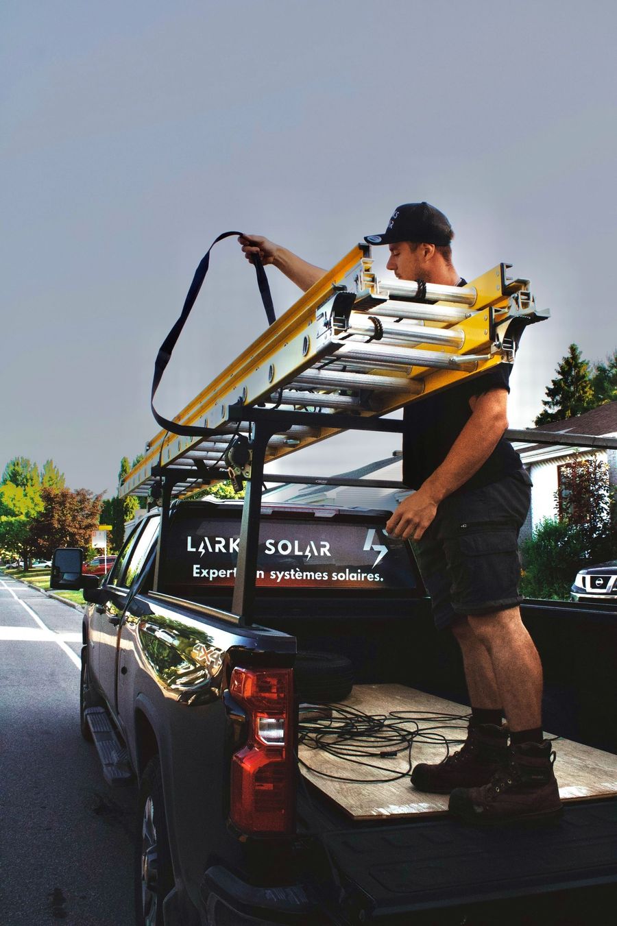 Membre de l'équipe Larks Solar qui charge l'échelle sur le camion de l'entreprise
