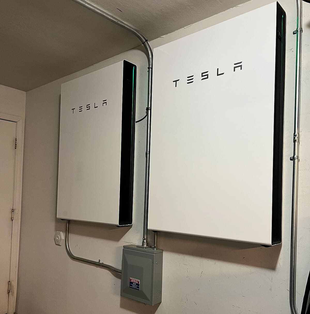 Deux batteries domestiques murales installées dans un garage