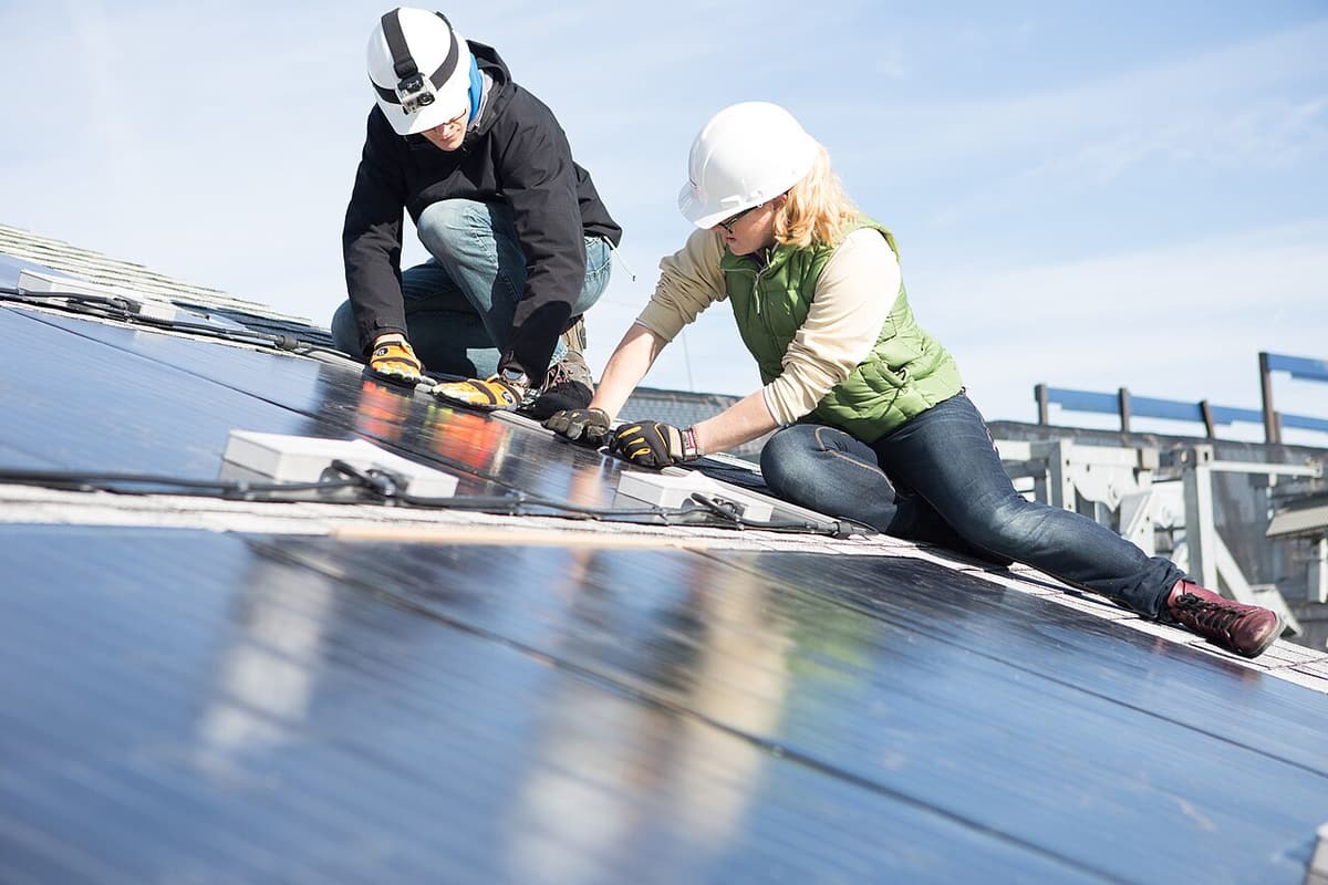 Installateurs qui fixent des panneaux solaires sur les rails