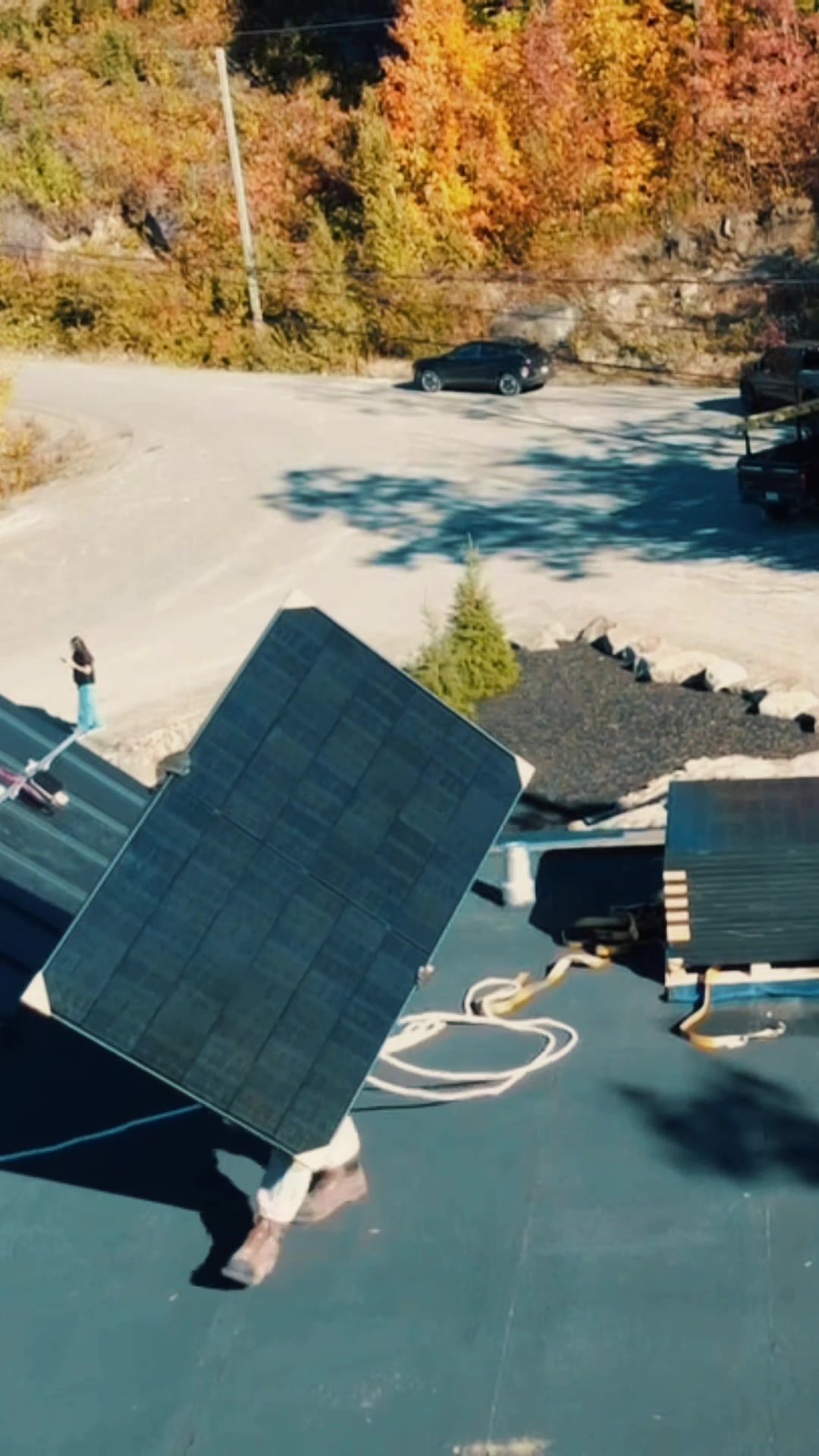 Panneau solaire hissé par une grue jusqu'au toit plat d'une maison de Sainte-Adèle, vu du drone