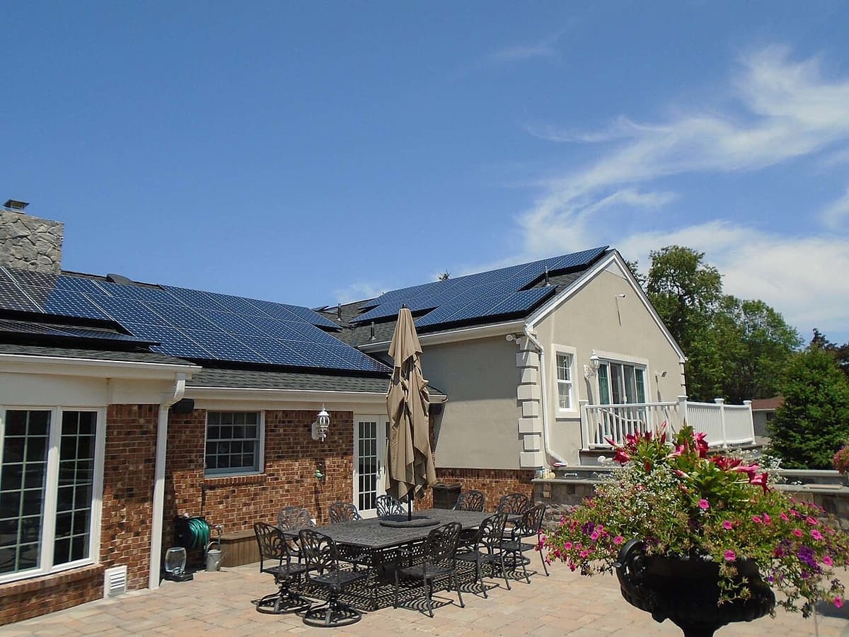 Maison en brique avec panneaux solaires, vue de la terrasse arrière