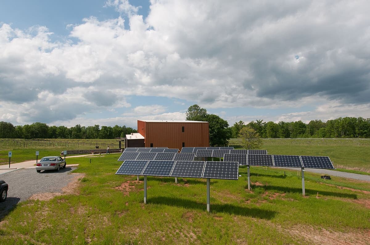 Panneaux solaires sur supports au sol près d'un bâtiment de ferme