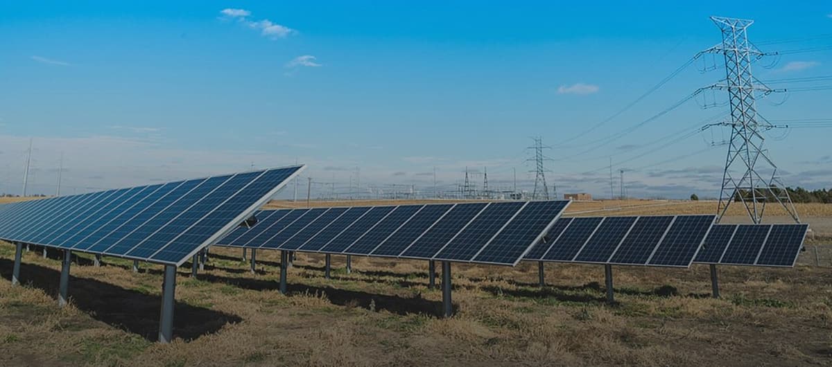 Panneaux solaires au sol dans un pâturage, sous des lignes électriques
